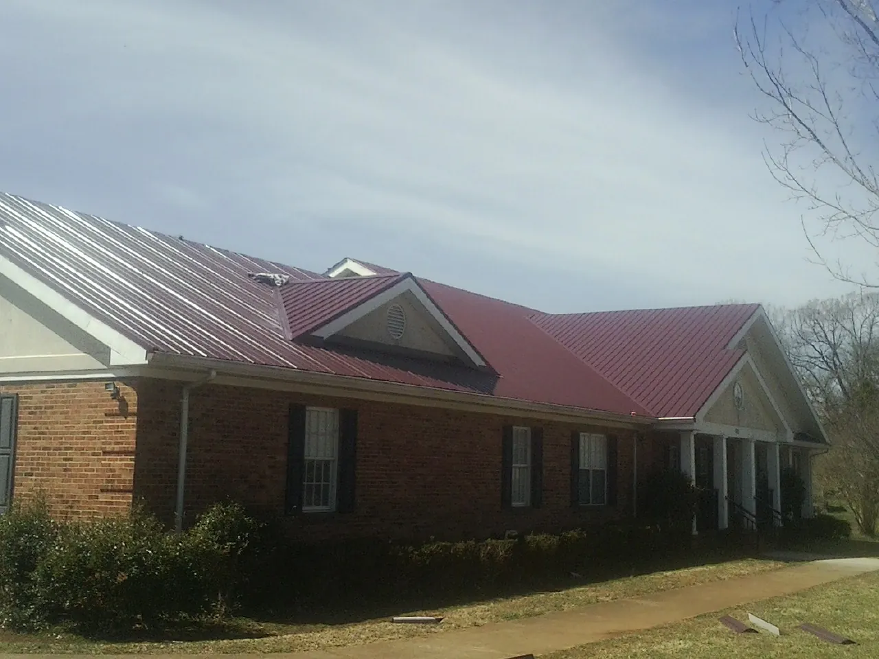 Red metal roof with gabled entries on a long brick building in East Vandergrift