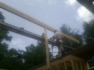 Carpenter setting a ridge beam over a new addition frame — Ice Dam Removal by Roofing Brothers in East Vandergrift