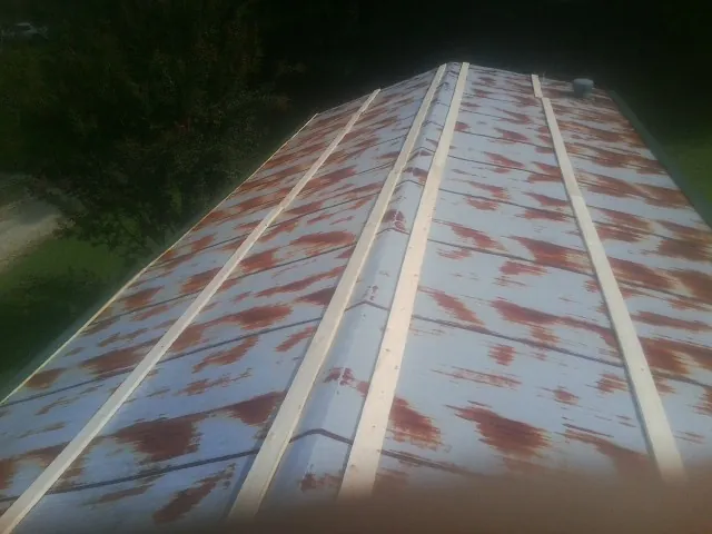 Rusted metal roof panels with new wood purlins before replacement — Storm Damage Roof Repair in East Vandergrift by Roofing Brothers