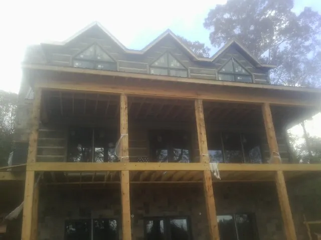 Dormers and porch framing on a large log home under construction — Roof Coating work by our crew in East Vandergrift