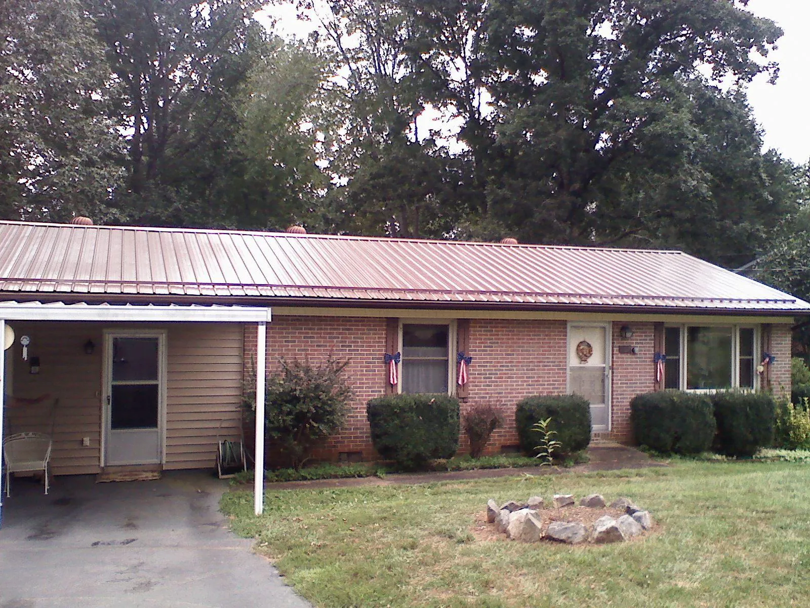 Bronze metal roof and carport on a brick ranch home — Roof Repair work by our crew in East Vandergrift