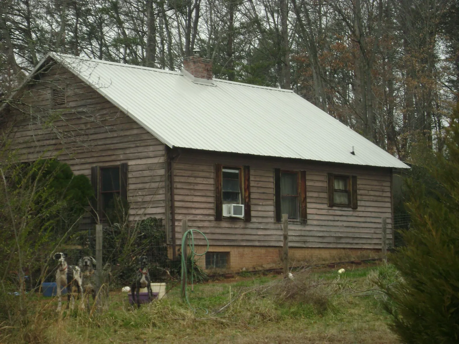 White metal roof on an old wood sided farmhouse, from a Metal Roof Installation job in East Vandergrift